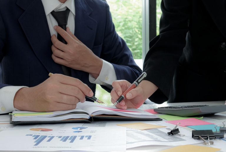 Executive is summarizing the work with secretary in the office.