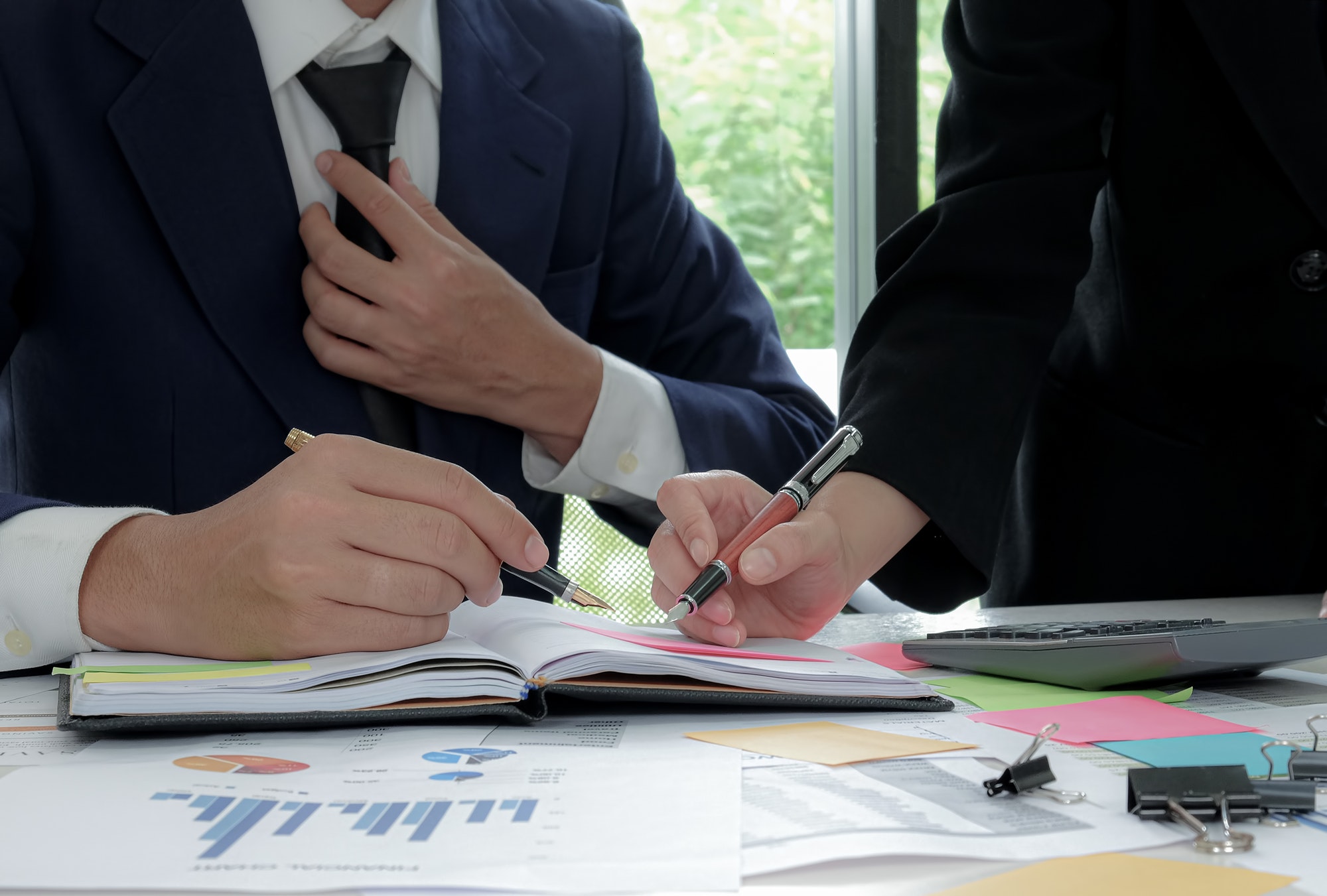 Executive is summarizing the work with secretary in the office.